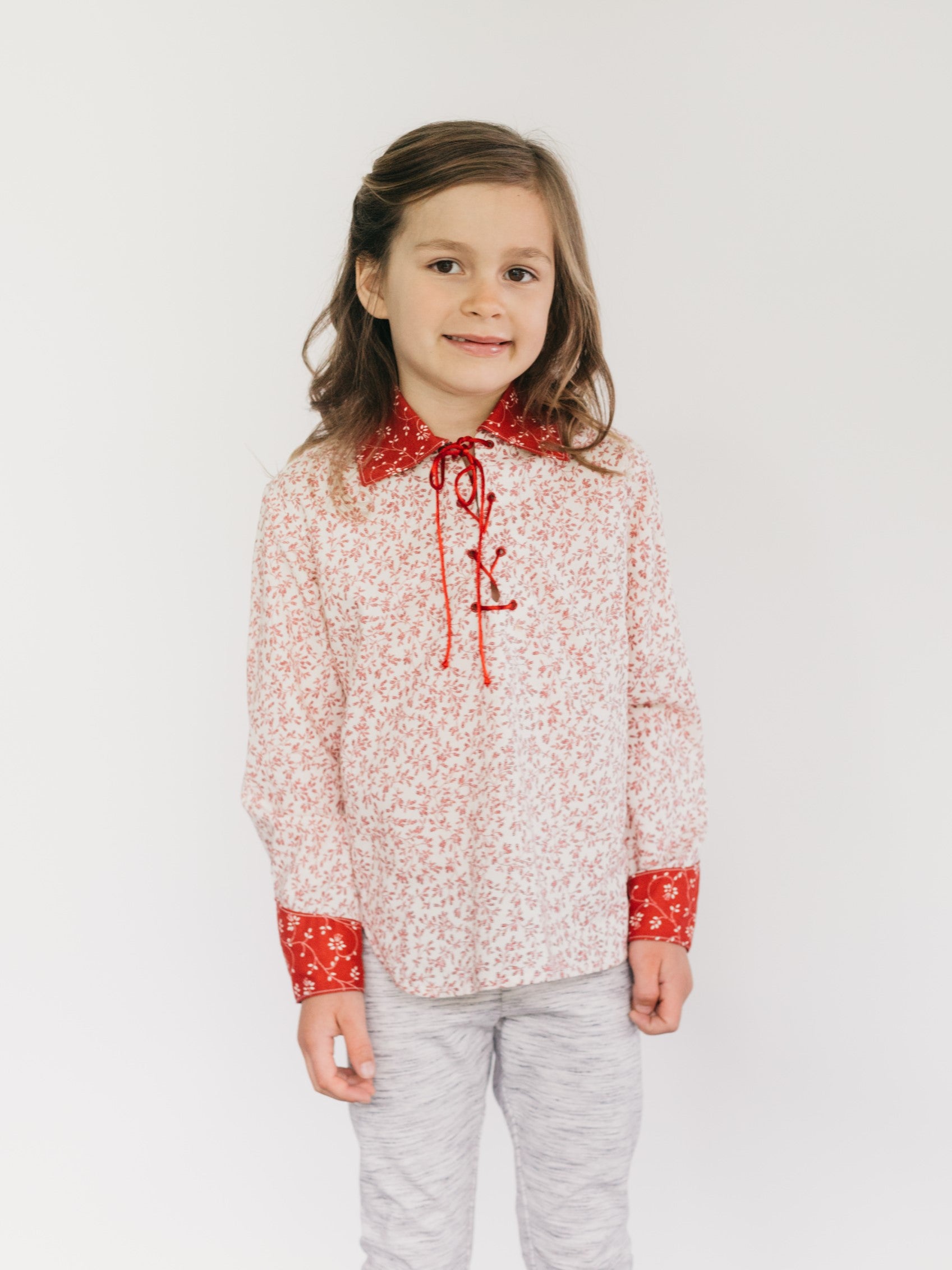 Young girl in a red floral Western shirt.