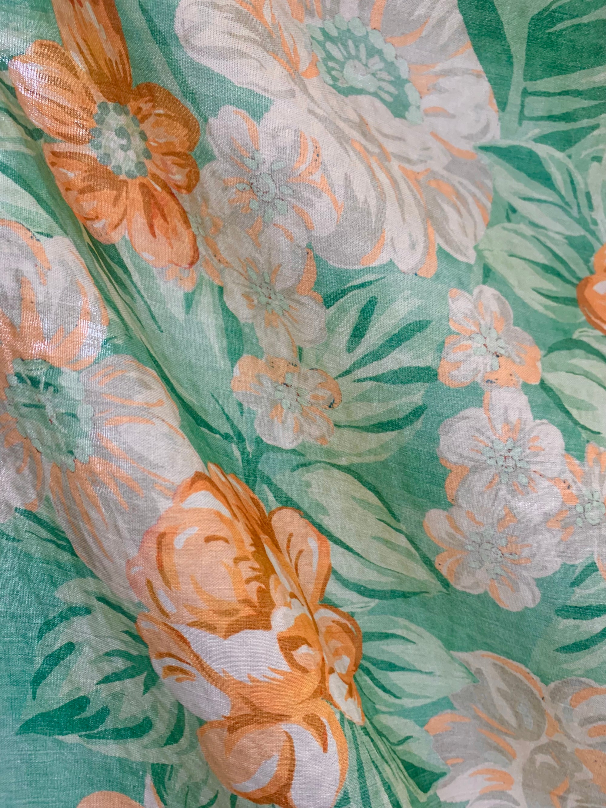 draped  summery flat cotton seersucker fabric with a muted orange and green tropical print