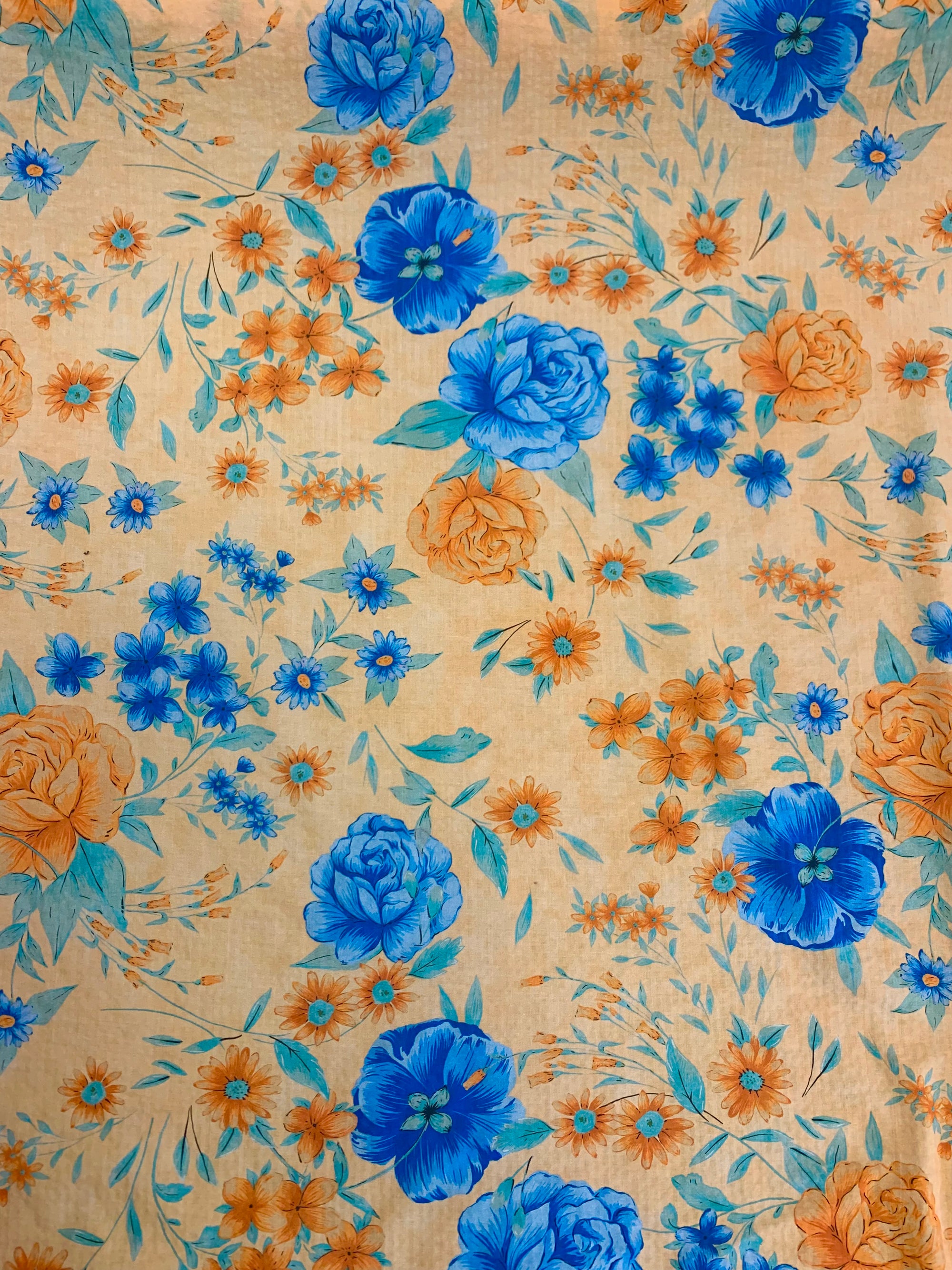 flat cotton seersucker in a pale orange with orange and royal blue floral print