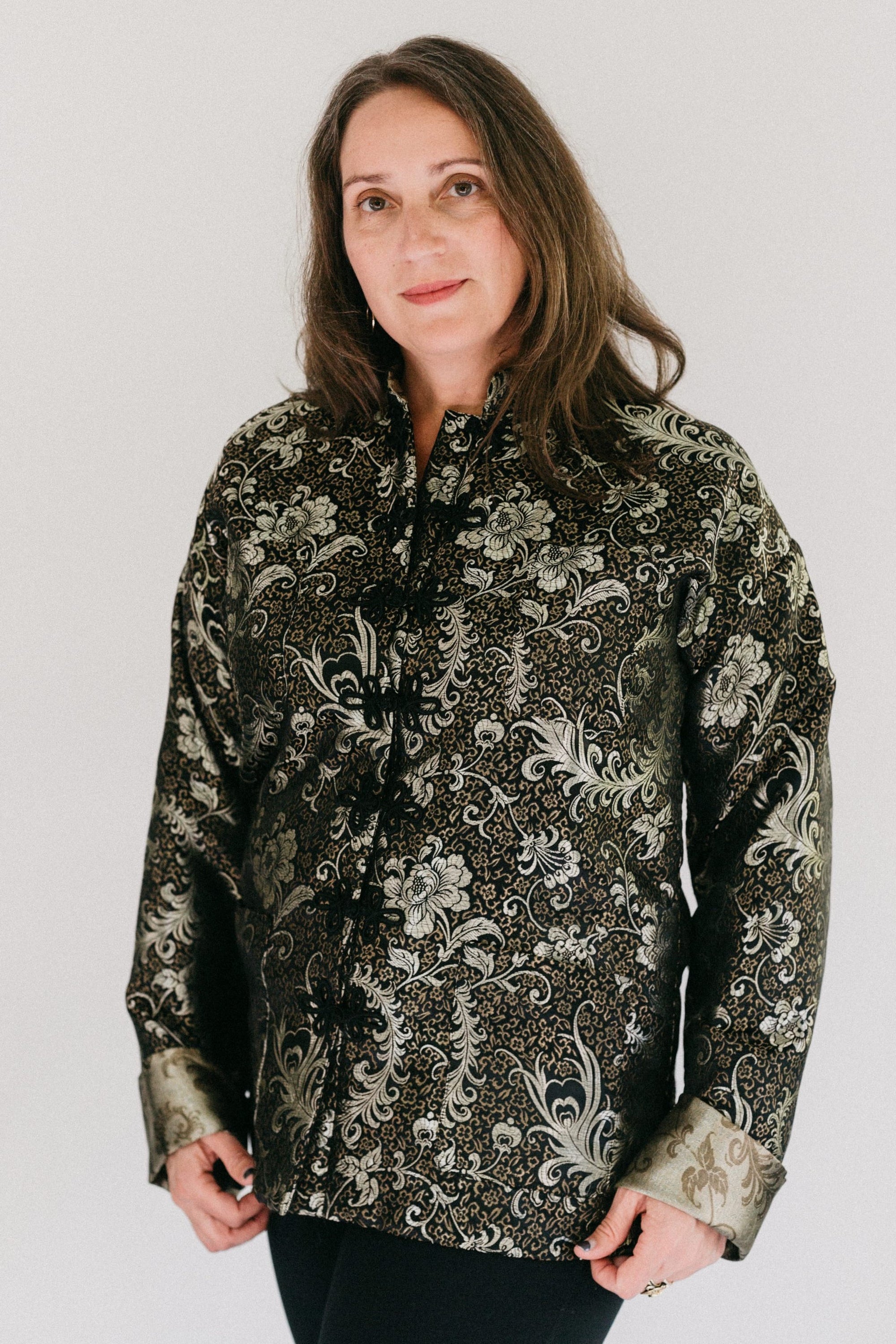 Brunette white woman standing in in front of a white studio backdrop wearing #145 Chinese Pajama jacket