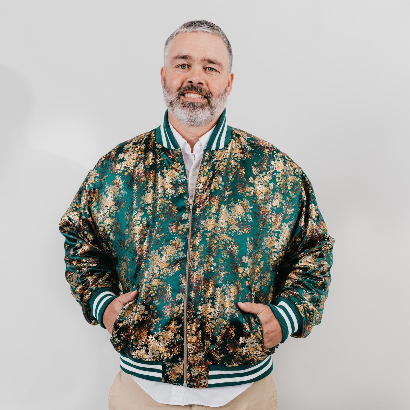 man wearing a green brocade varsity jacket