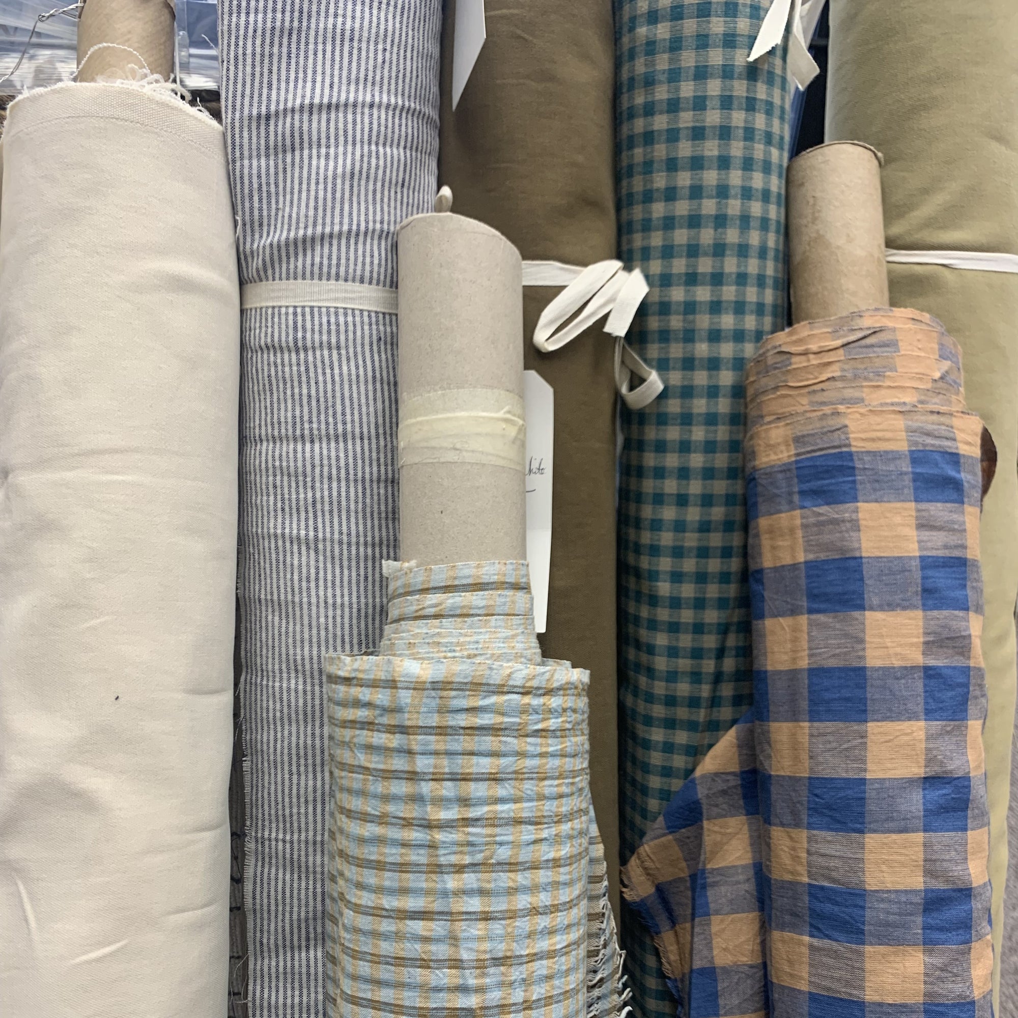 Rolls of fabric with colors of blue, orange, ecru and white