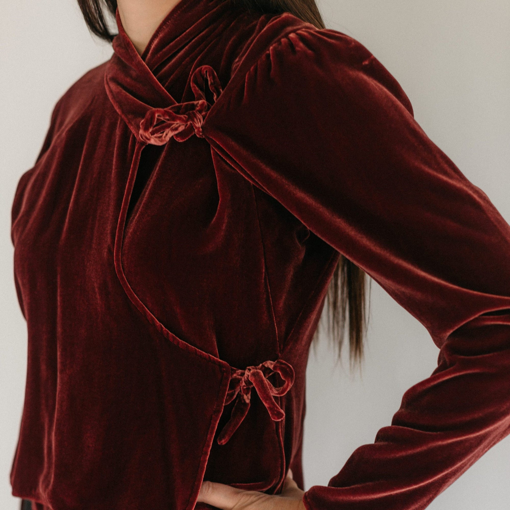 Close up of woman wearing a red velvet wrap shirt.