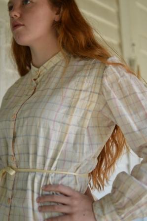 Close up of young red head woman standing faced to the left with hand on her hip wearing 216 Schoolmistresses Shirtwaist. 