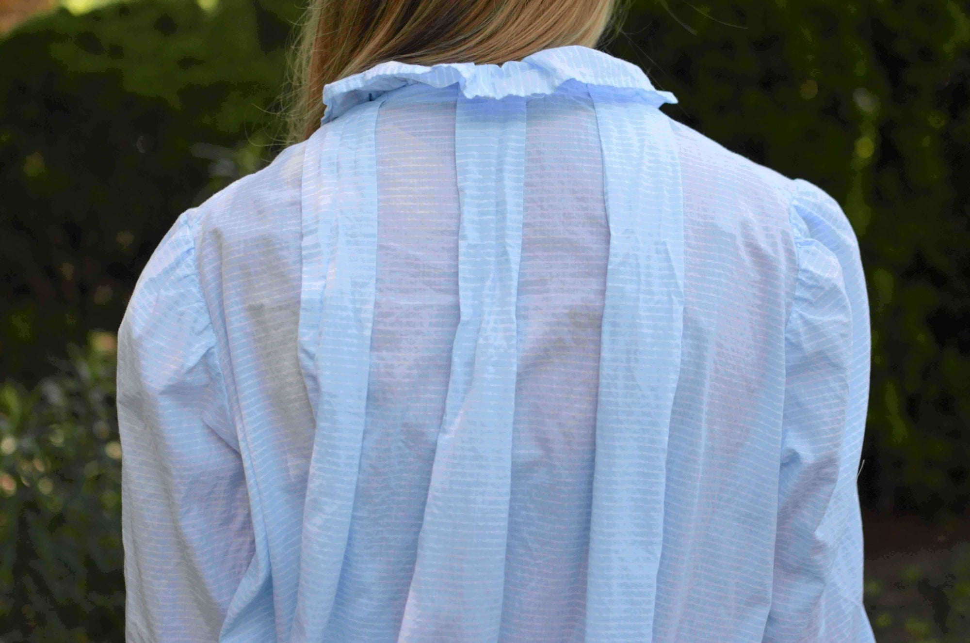 closeup of top of back of blue nightgown with three box pleats.