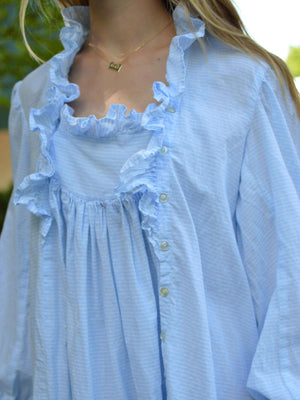 Close up of front of blue nightgown with ruffles and buttoned side placket.