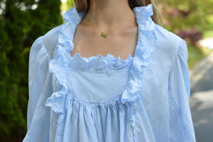 close up of front of blue night gown with ruffles at neckline.