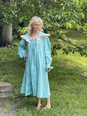 woman standing outside with teal ruffled nightgown.