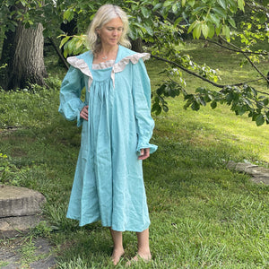 woman standing outside with teal ruffled nightgown.