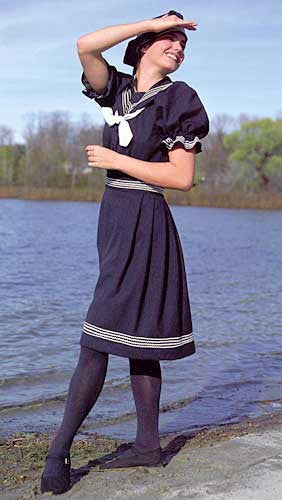 Young brunette white woman standing by a lake shading her face with her hand wearing the 253 Vintage Bathing Costume. 