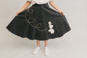Close up of the At The Hop skirt fanned out with her hands,with poodle design