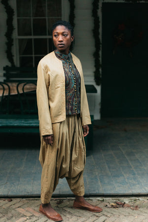 Person wearing a gold Algerian Suit with green vest outside.
