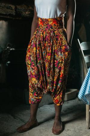 Person wearing colorful floral harem pants (from the Algerian Suit) in a rustic setting