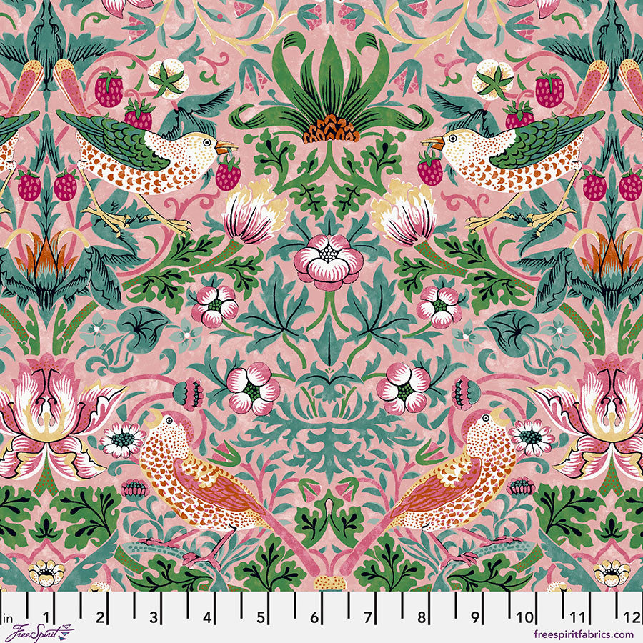 Patterned fabric with birds and flowers picking strawberries on a pink background, with green, teal, and pink foliage. With a ruler at the bottom.