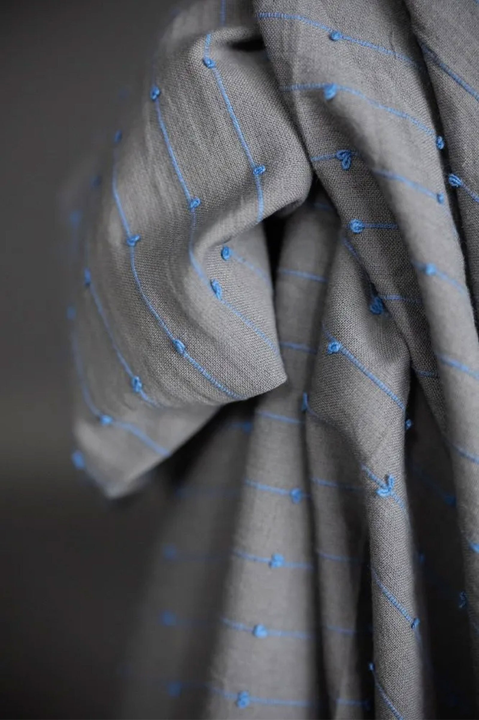 A unique slubby Indian cotton with woven colourful loops. A dusty grey/blue background with cornflower blue loops. 