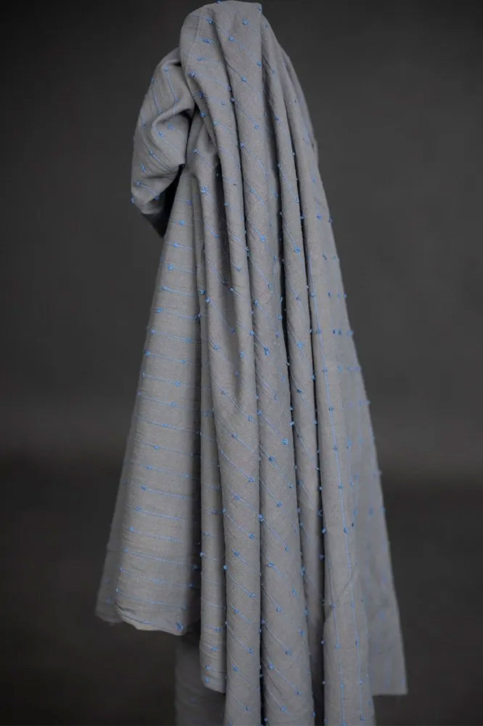 A unique slubby Indian cotton with woven colourful loops. A dusty grey/blue background with cornflower blue loops. 