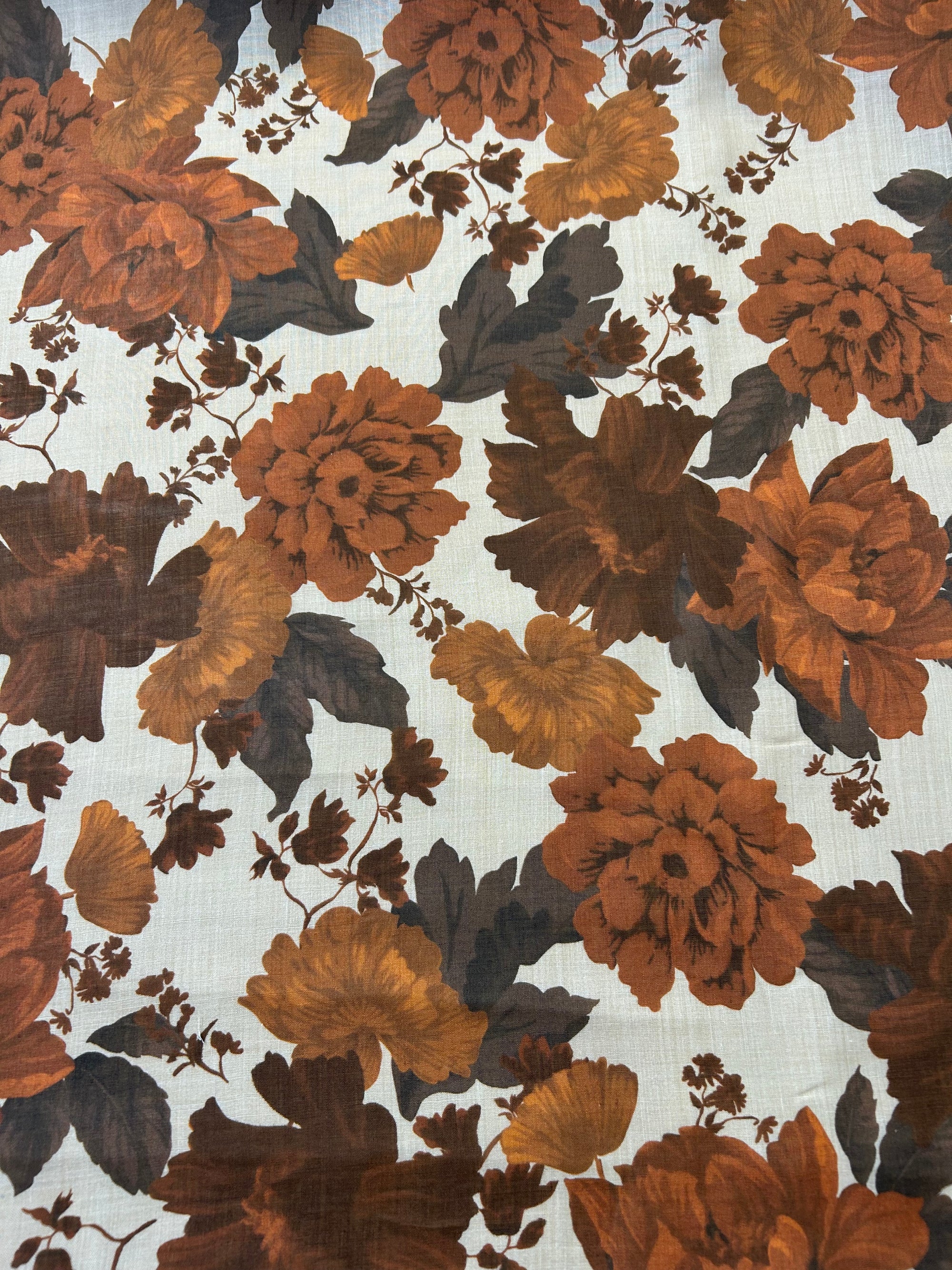 Floral peony pattern with brown and orange flowers on a light tan background.
