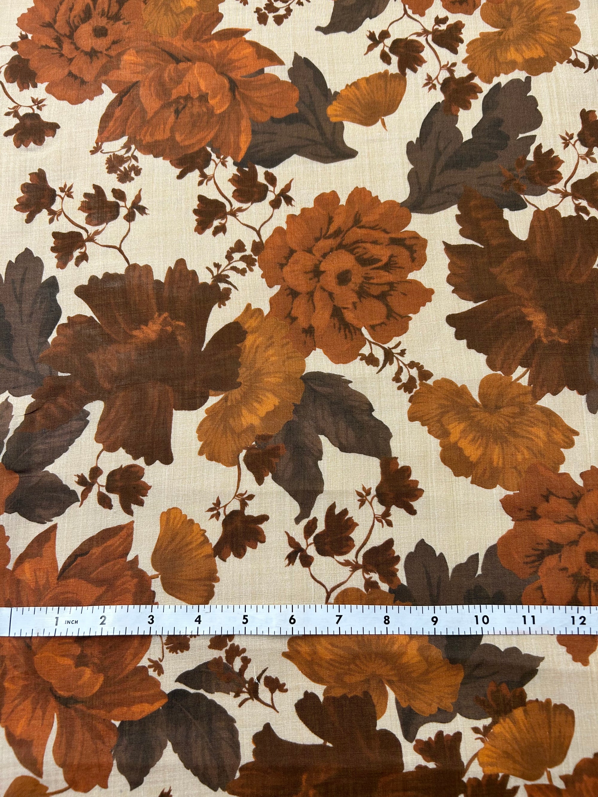 Floral peony pattern with brown and orange flowers on a light tan background, with a ruler for scale.