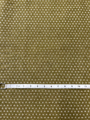 Brown fabric with a subtle  dots pattern and a ruler for scale on a matching brown background