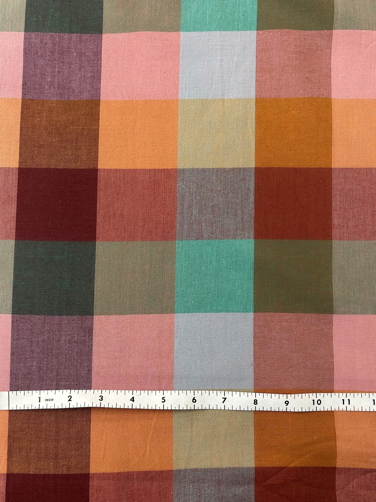 Multicolored checkered fabric with pinks, purples, oranges blues and greens, summer and autumn colors.