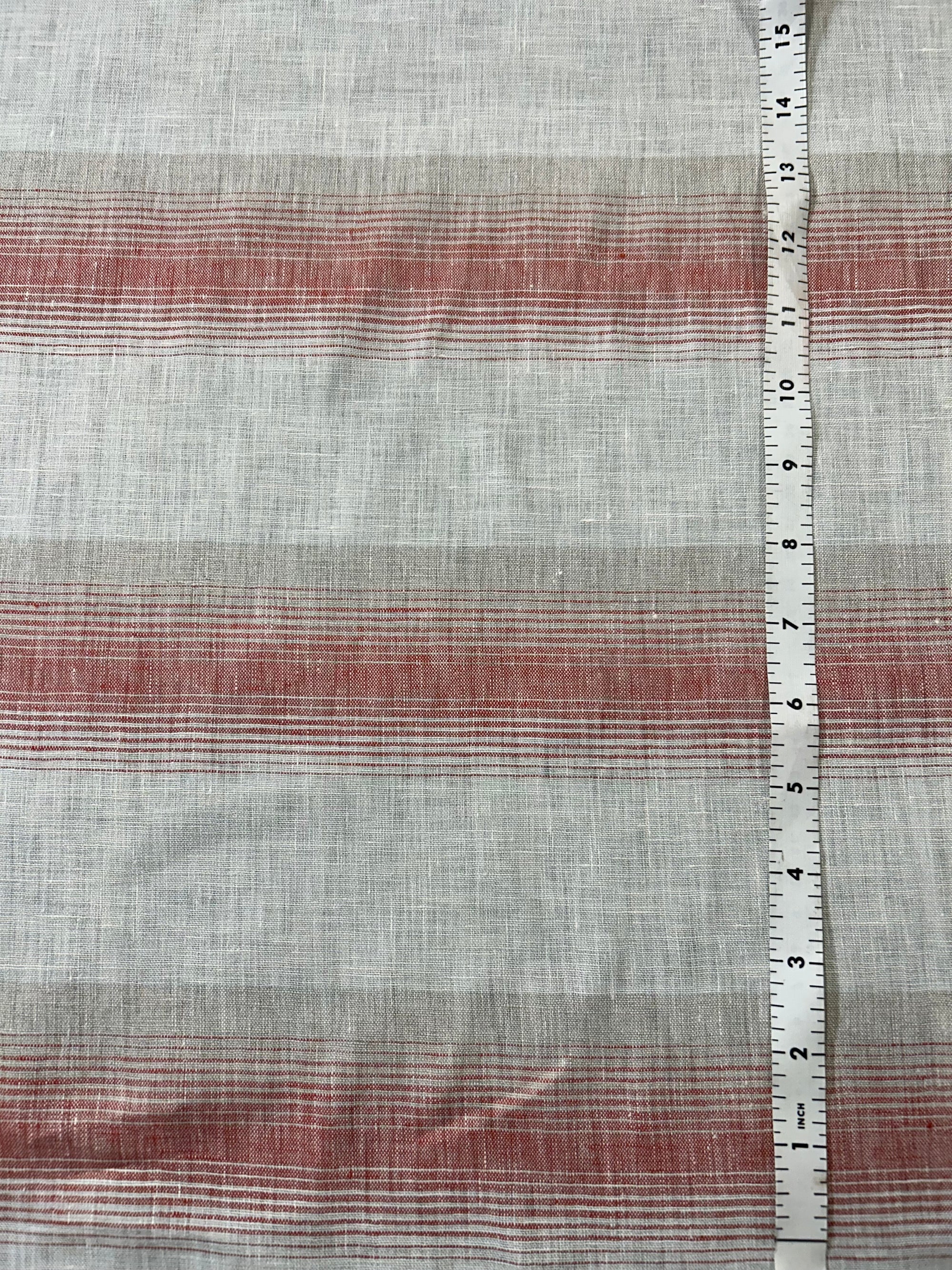 Red and white stripe linen fabric with a white measuring tap on the right.