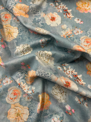 Floral fabric pattern with a pale blue background and large peonies in white and peach draped.