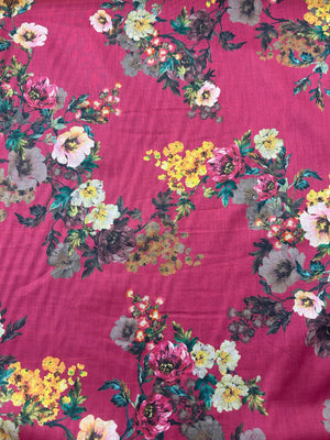 Cotton voile fabric with a vibrant and unsaturated floral print with white, burgundy and yellow flowers on a maroon background 
