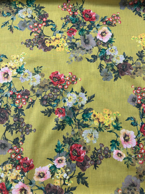 This is a cotton voile with a vibrant and unsaturated floral print of yellow, pink and red flowers on yellow background.