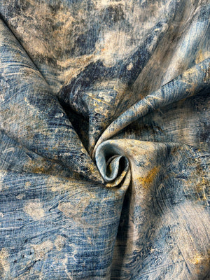 Close up of blue paint brush stroke fabric with hints of white and yellow in a swirl.