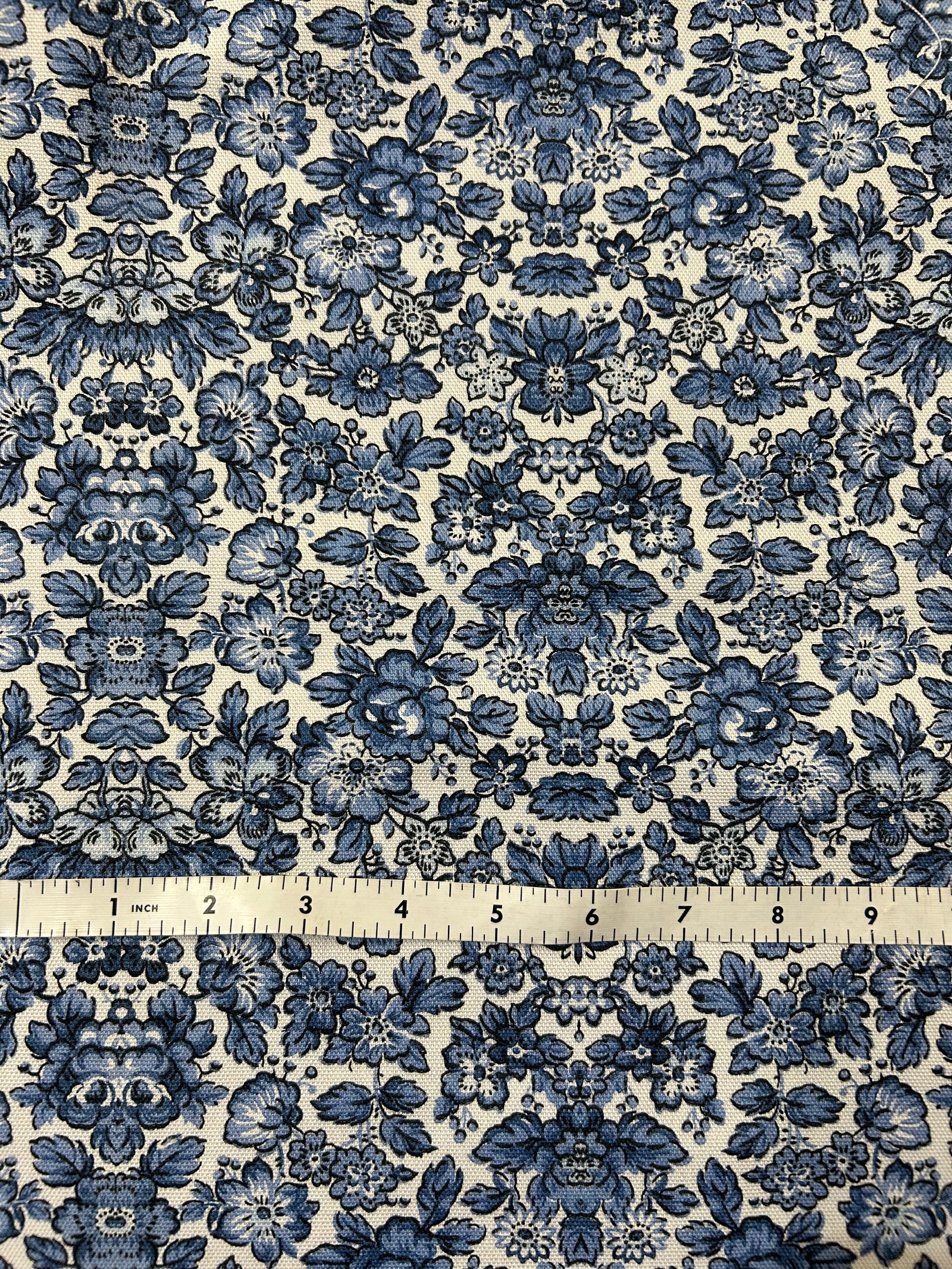 Blue floral cotton canvas fabric on a ecru background.