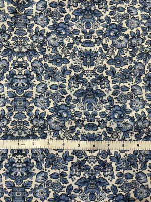 Blue floral cotton canvas fabric on a ecru background with a measuring tape for scale.