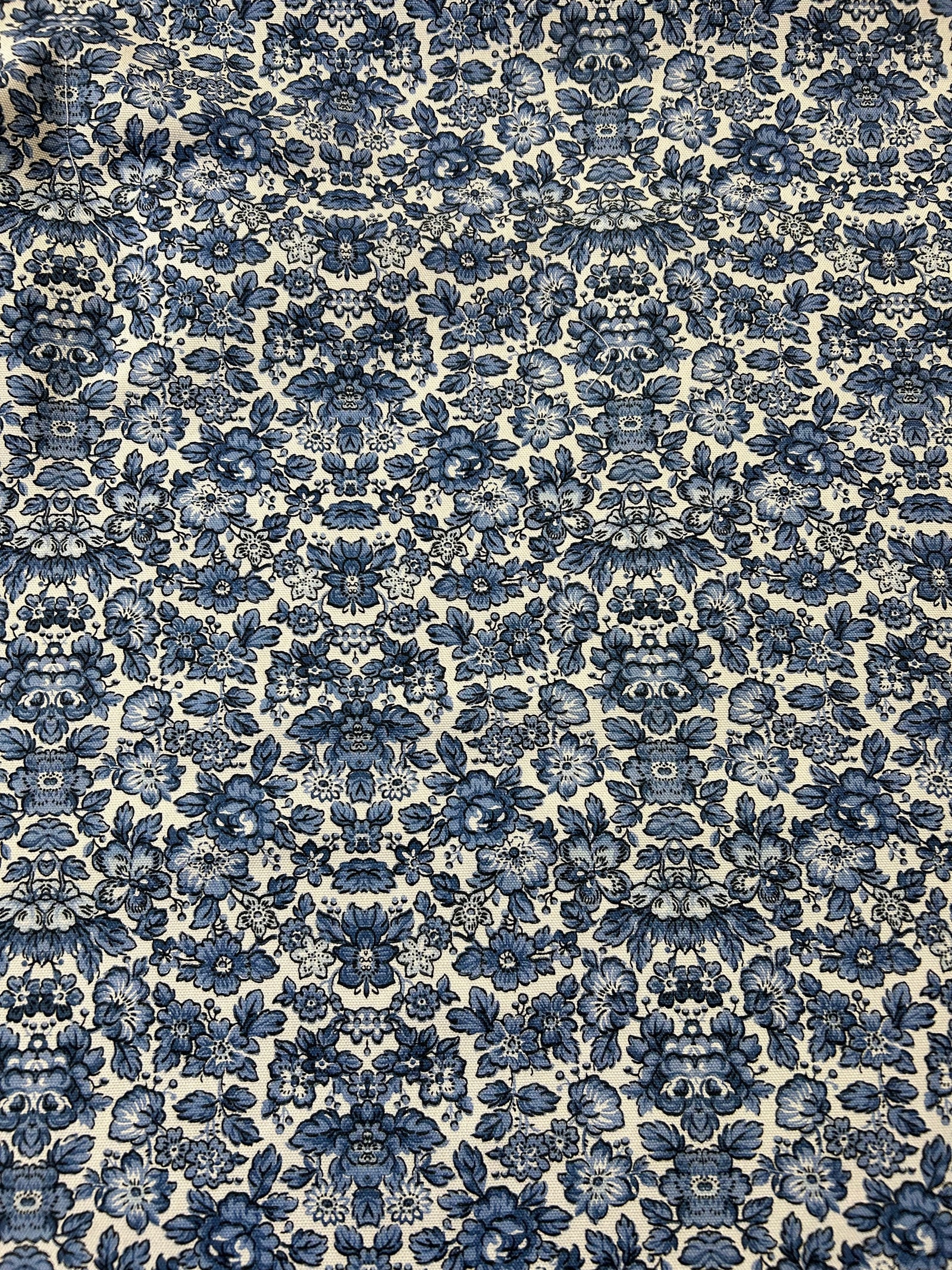 Blue floral cotton canvas fabric on a ecru background.