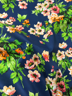 Floral pattern on fabric with pink, orange, and green flowers on a navy background