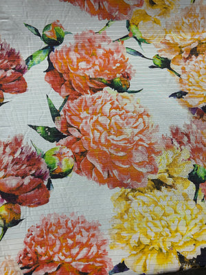 Floral patterned fabric with large flowers in orange, yellow, and red on a white background.