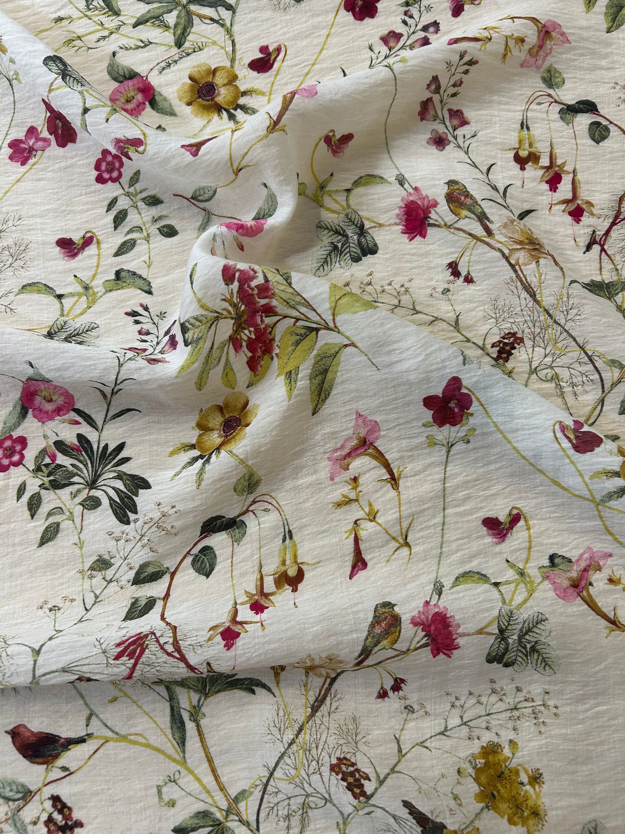 Floral fabric pattern with pink, red, and green flowers on a beige background