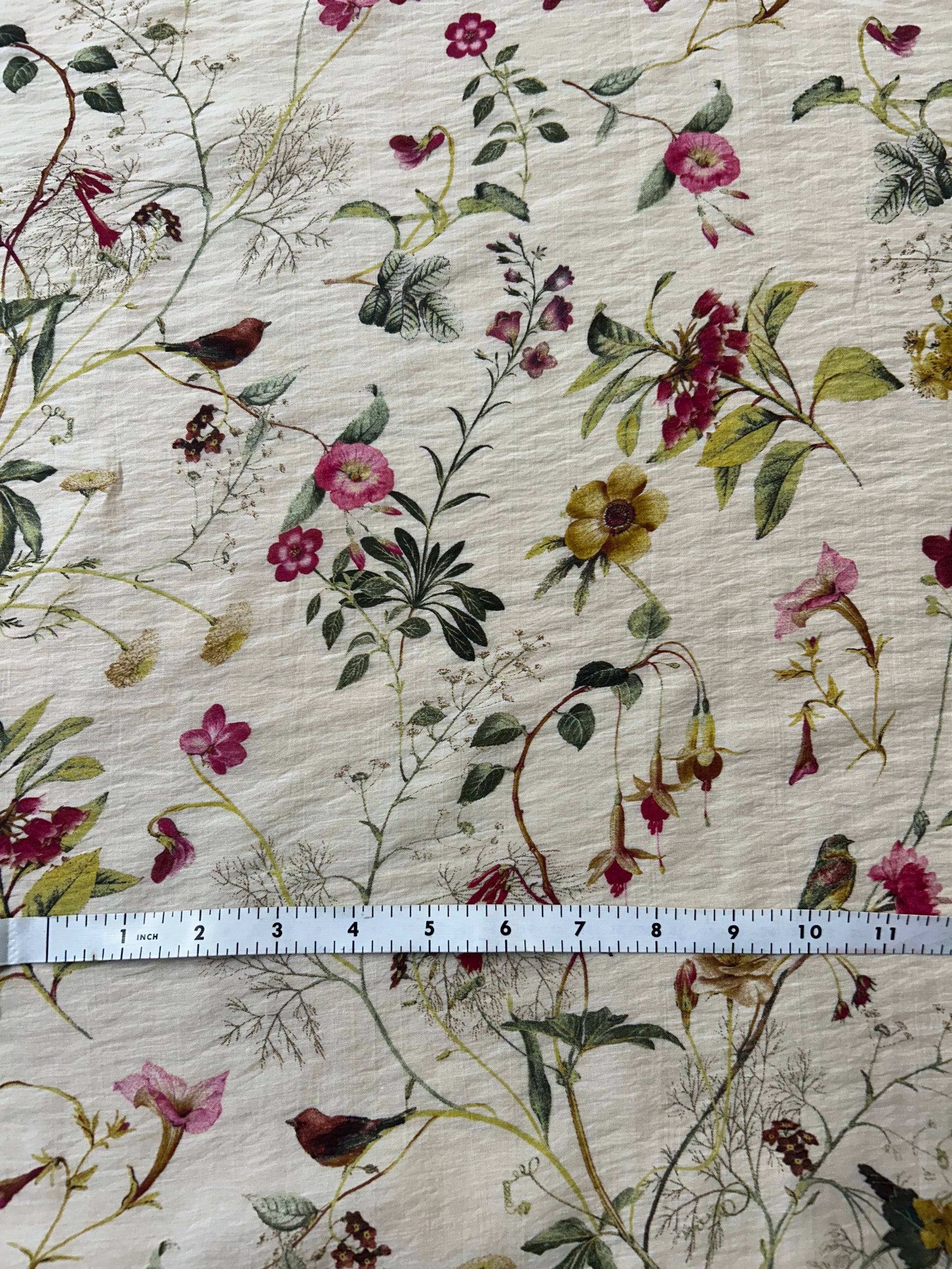 Floral fabric pattern with a ruler for scale on a beige background
