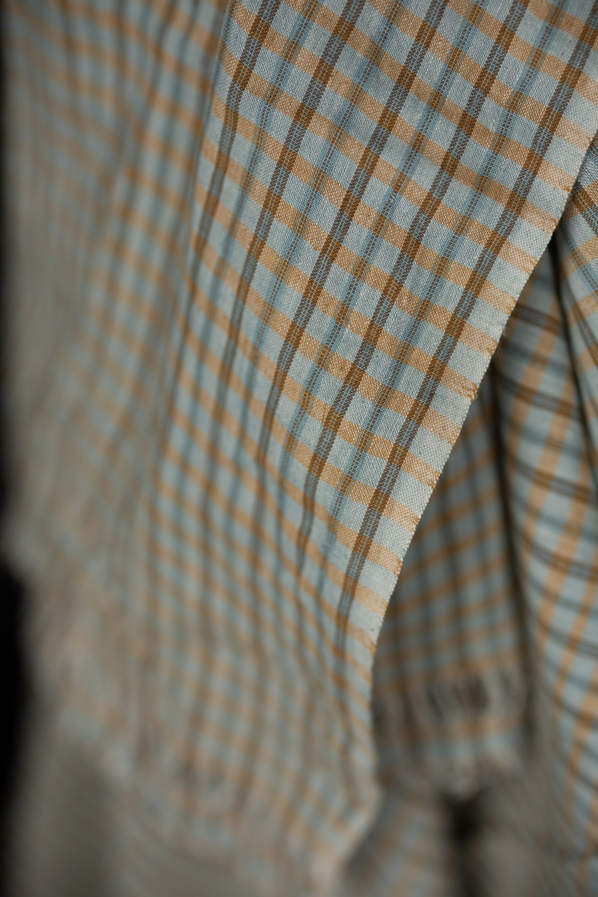 Close up of fabric in a pale blue and pale orange plaid.