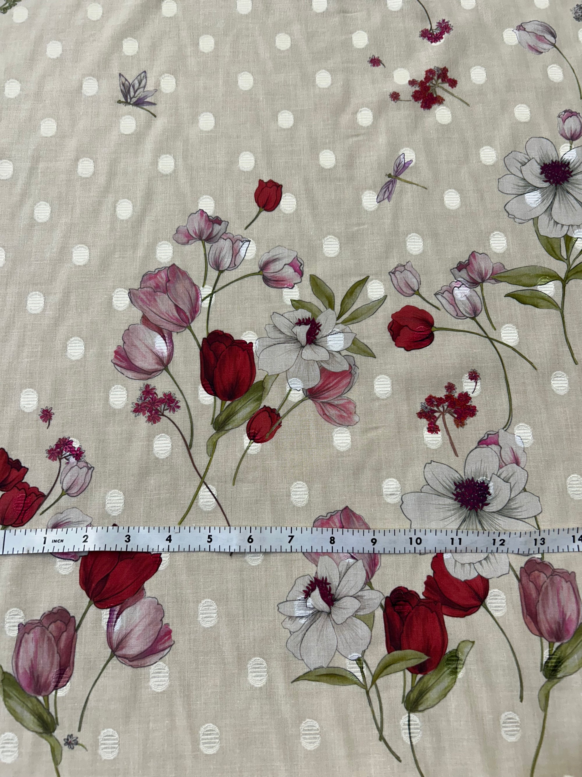 Floral pattern with red and purple tulip flowers on an ecru background with white polka dots and a ruler for scale.