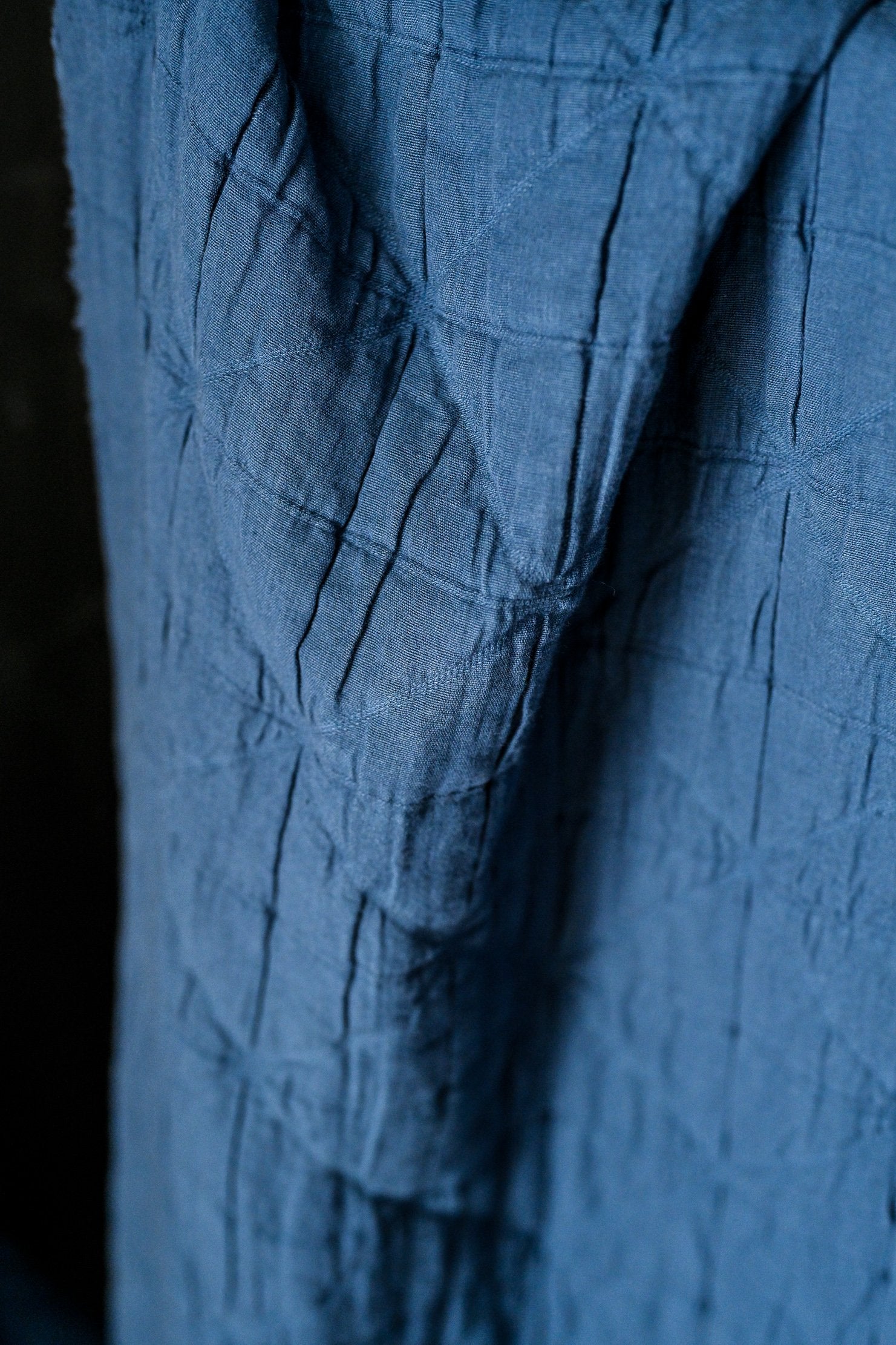 close up marine blue jacquard fabric in a light grey background