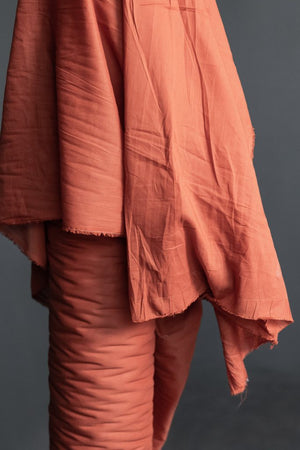 orange cotton voile fabric on a dark grey background.