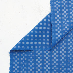 a 100% cotton fabric in a beautiful stunning bright blue color with pale blue woven textured checkered pattern.