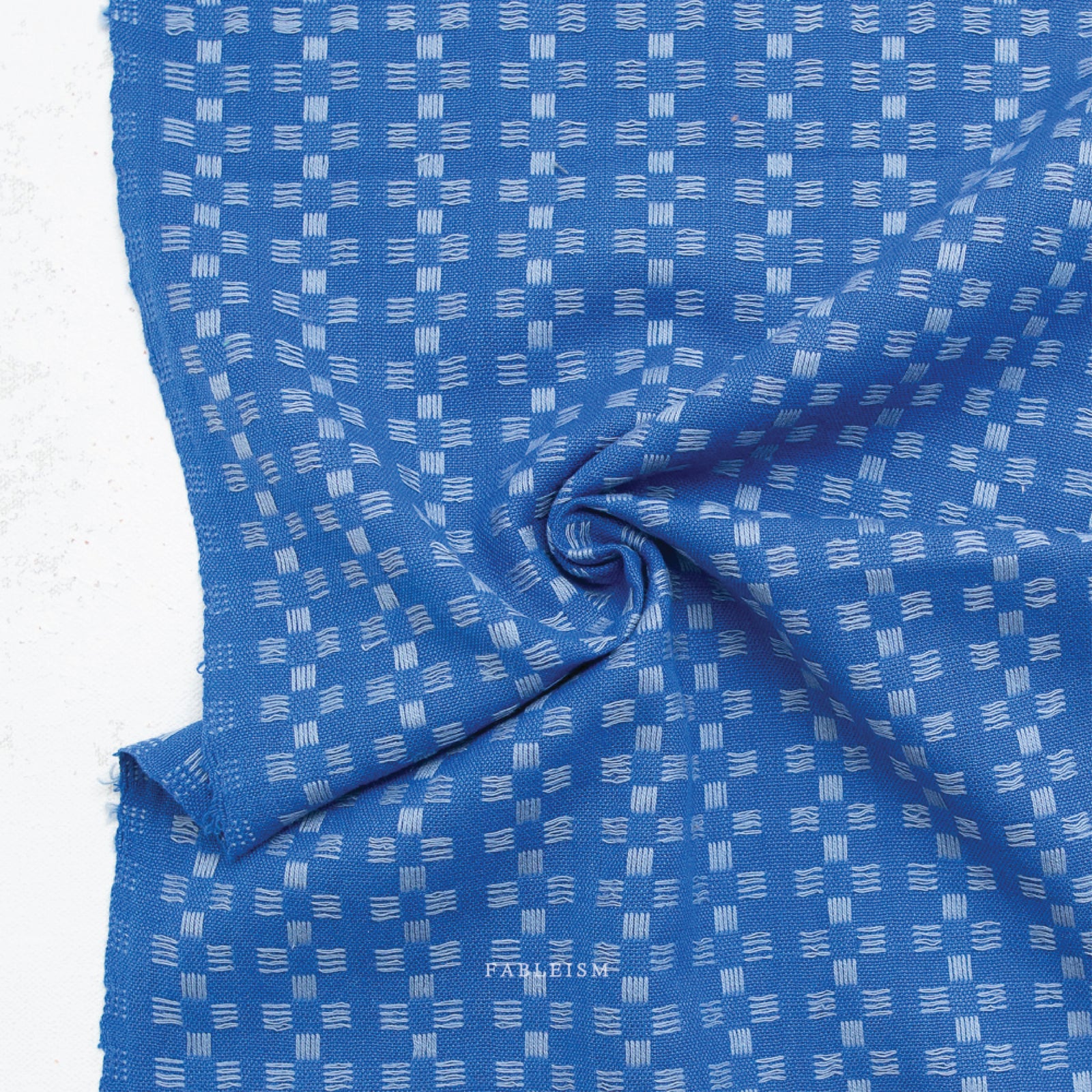 a 100% cotton fabric in a beautiful stunning bright blue color with pale blue woven textured checkered pattern.