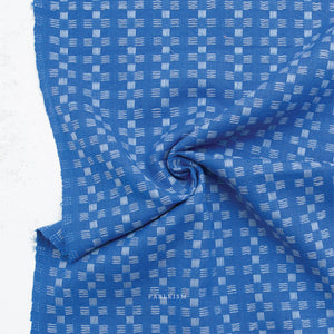 a 100% cotton fabric in a beautiful stunning bright blue color with pale blue woven textured checkered pattern.
