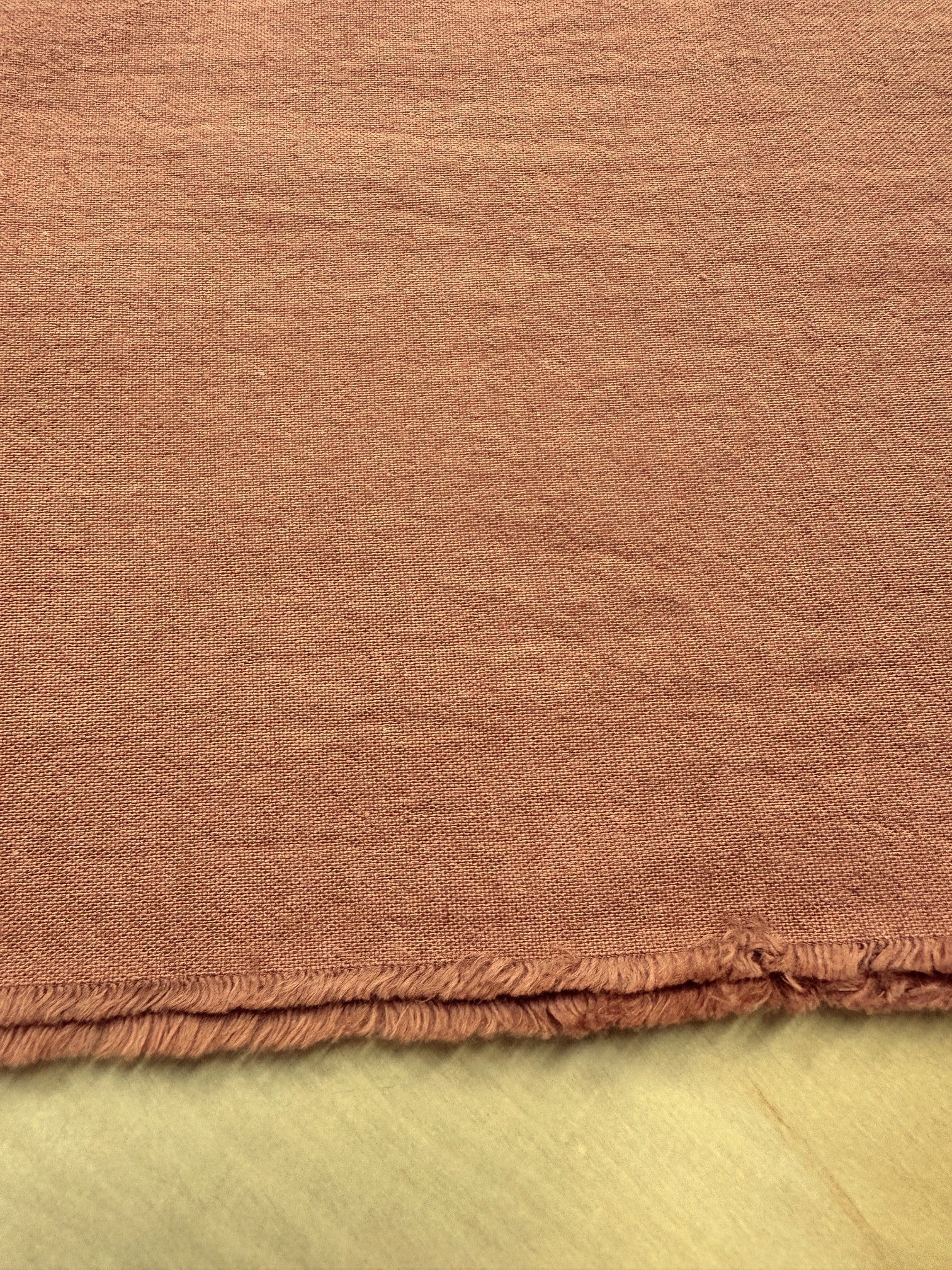 section of burnt orange colored cotton/linen fabric on a table