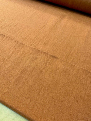 section of burnt orange colored cotton/linen fabric on a table