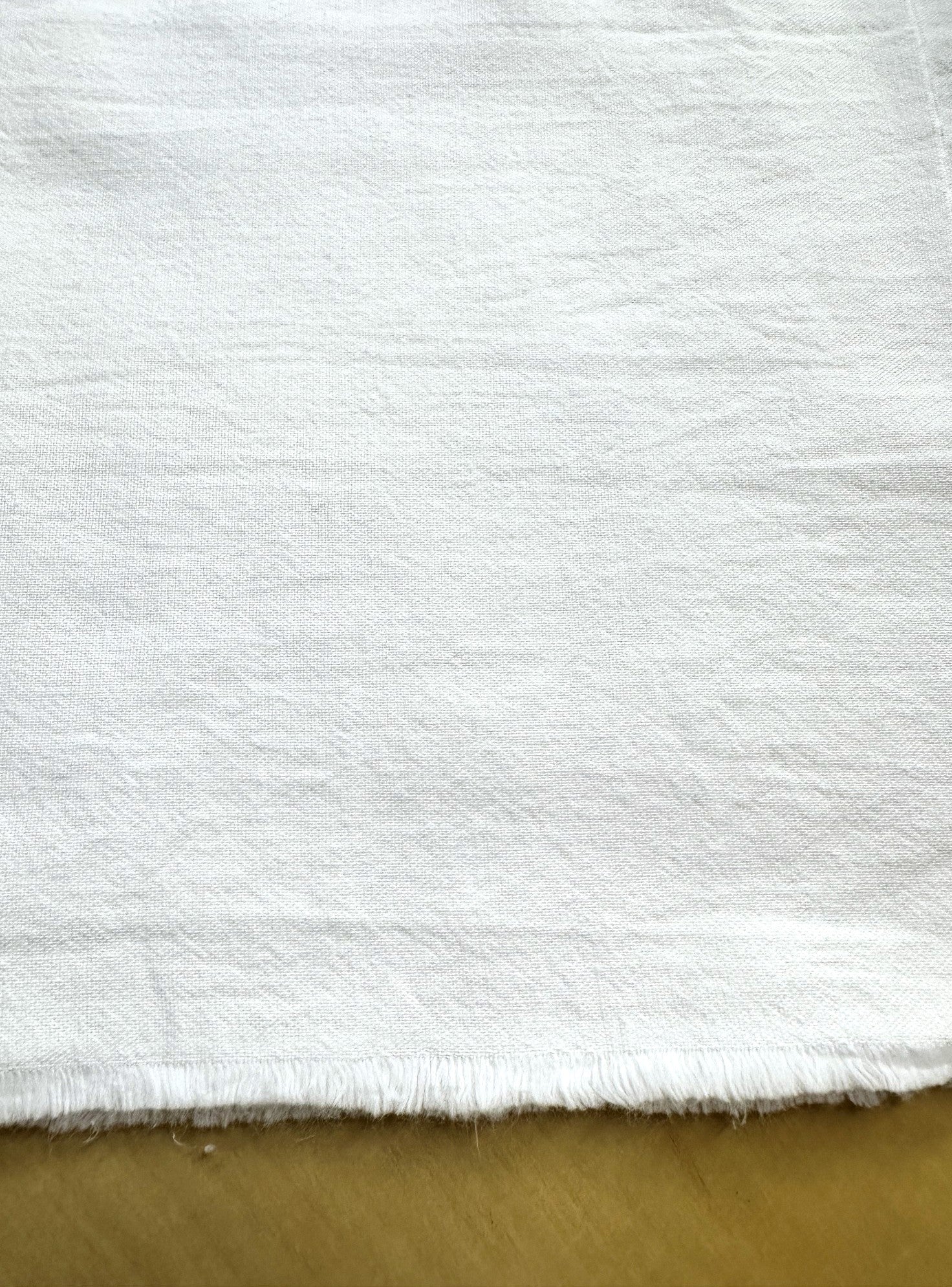 section of bright white fabric on a wooden table