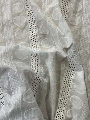 Close-up of a textured fabric with circular patterns in gray tones.