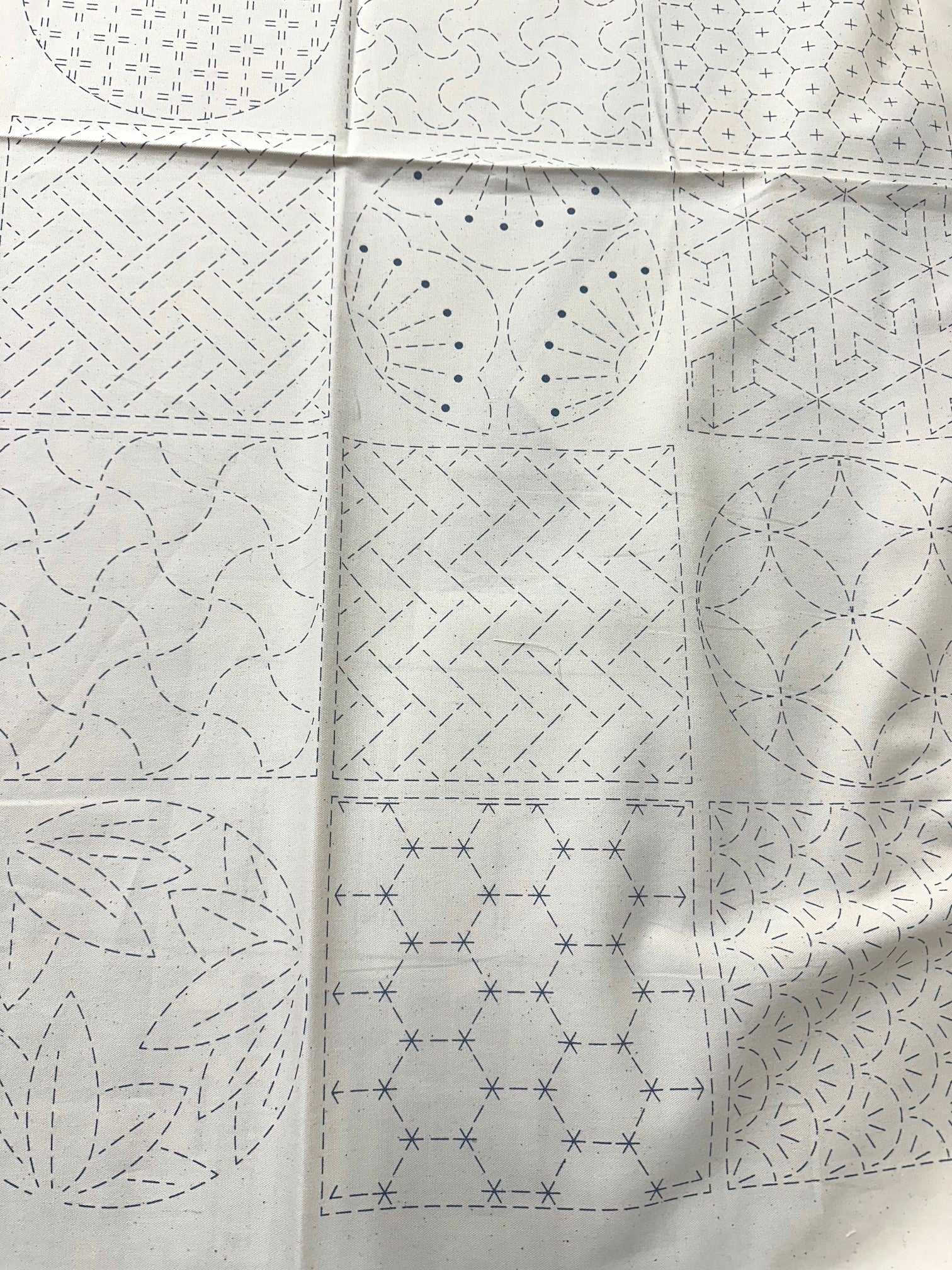 Two  pieces of sashiko fabric with different patterns on a white background.