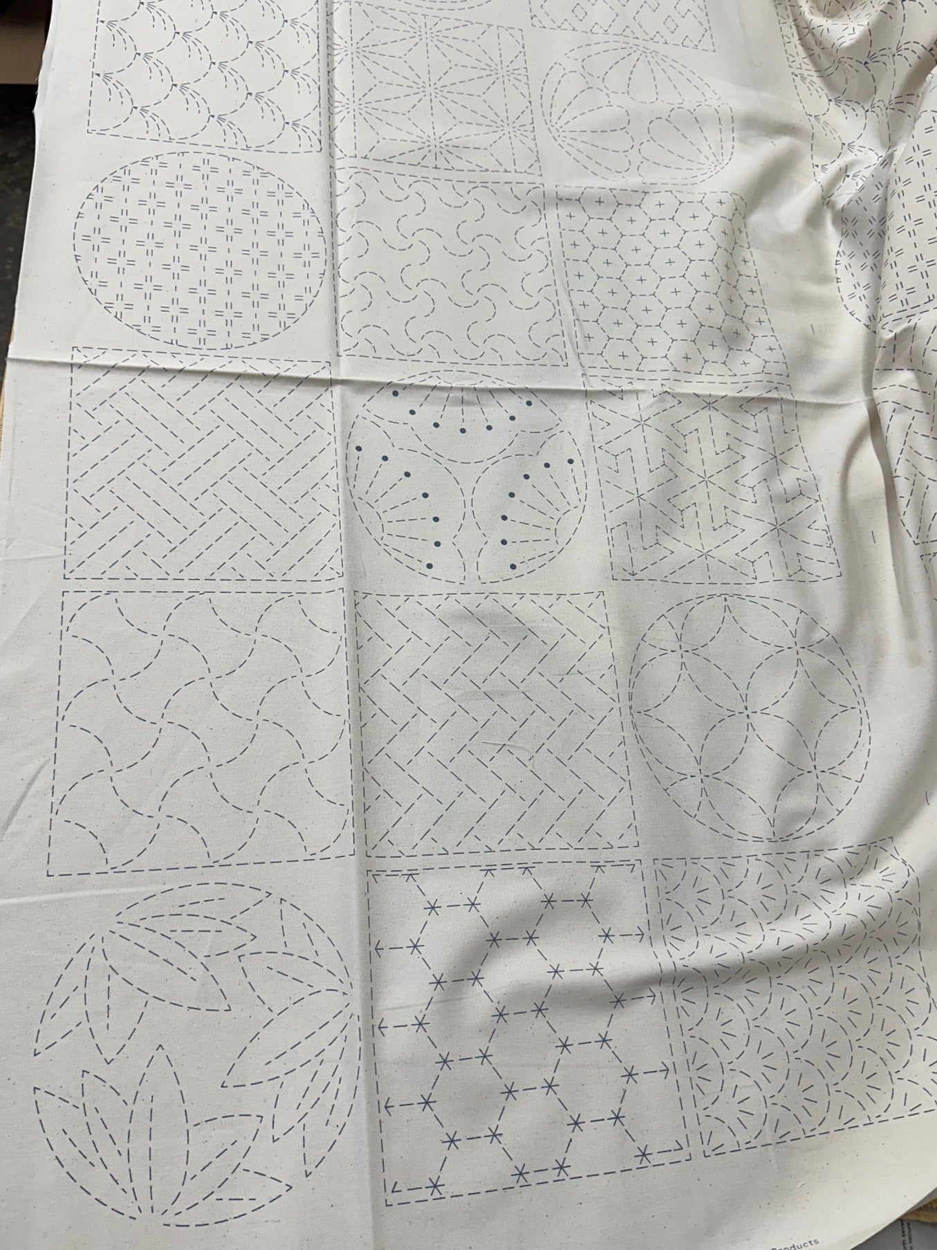 cream colored fabric with sashiko design squares printed on it.