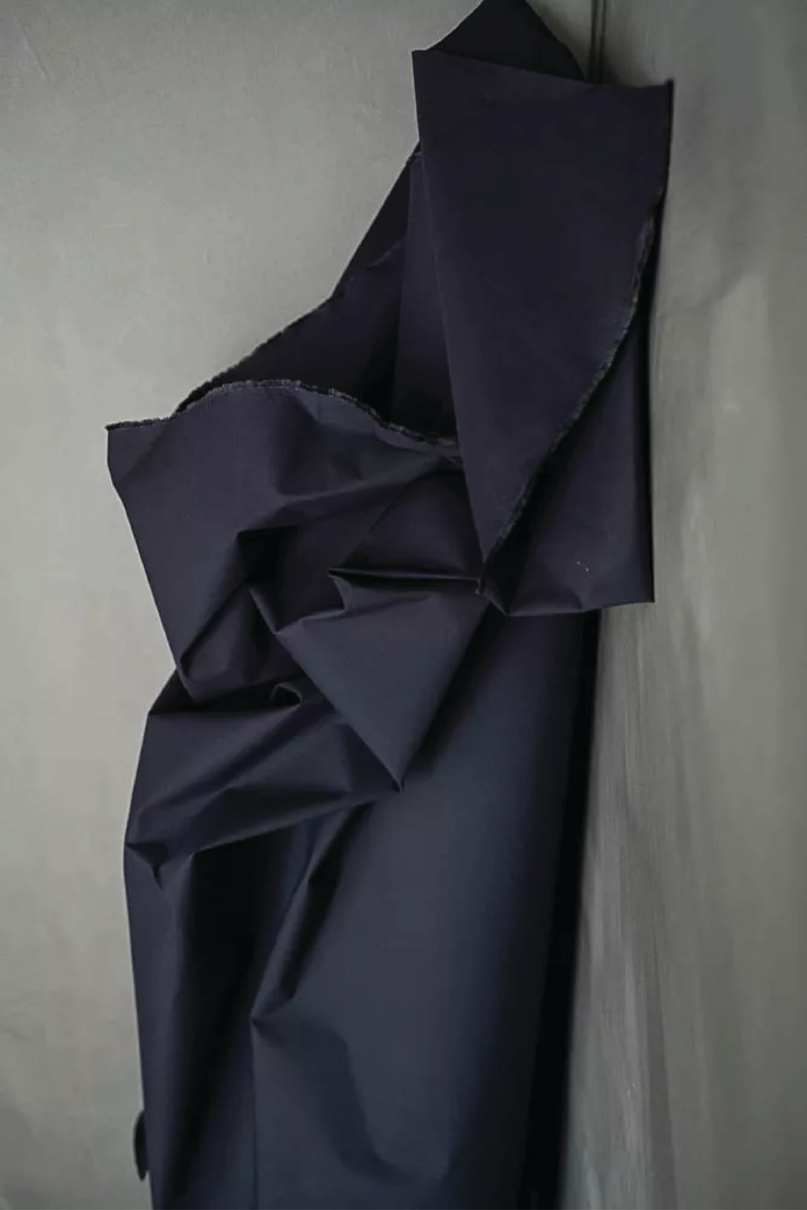 Navy blue fabric draped over a light grey green surface